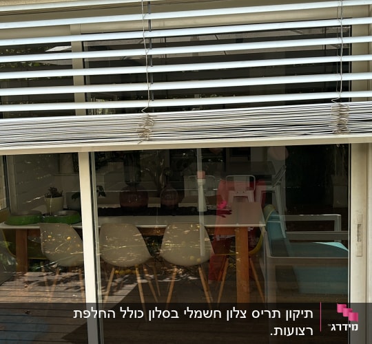 תריסים לבנים פתוחים למחצה על חלון זכוכית
